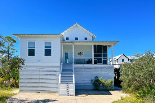 a white house with a door on a garage at Windmark - Sunset by the Bay in Highland View
