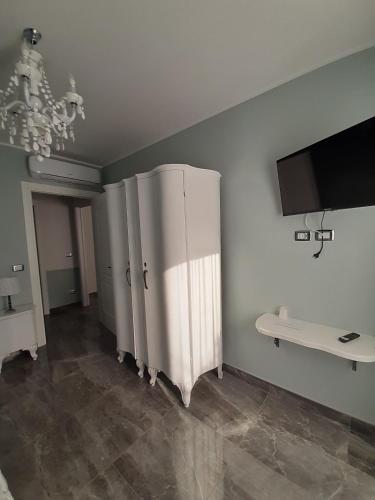 a living room with a white refrigerator and a tv at B&B Domus Aurea 20 in San Giovanni Teatino