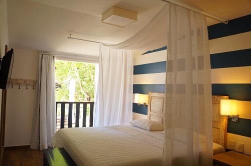 a bedroom with a bed with blue and white stripes at Pousada da Prainha in Arraial do Cabo