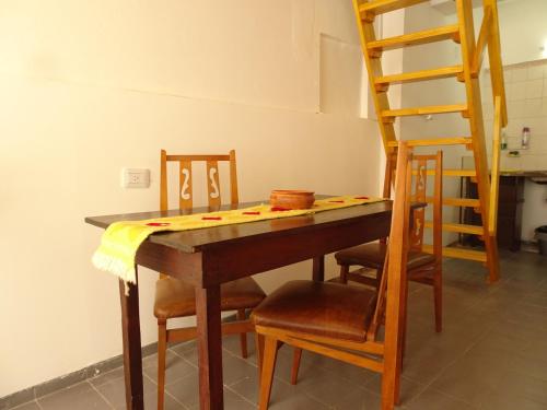 mesa de comedor con sillas y escalera en Del Valle Apartamentos 285 en Valle Hermoso