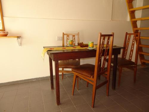 mesa de comedor con 4 sillas, mesa y escalera en Del Valle Apartamentos 285 en Valle Hermoso