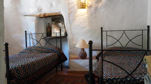 sypialnia z 2 łóżkami i lampką w obiekcie Cortijos Rey Fini w Grenadzie