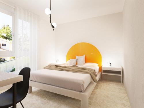een slaapkamer met een bed met een geel hoofdeinde bij Spacebility Beach - self check-in in Quartu SantʼElena