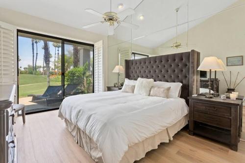1 dormitorio con cama grande y ventana grande en Sunny Palm Desert Escape on Golf Course, en Palm Desert