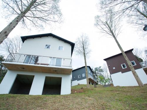 uma casa no topo de uma colina com árvores em Matsue Forest Park em Matsue
