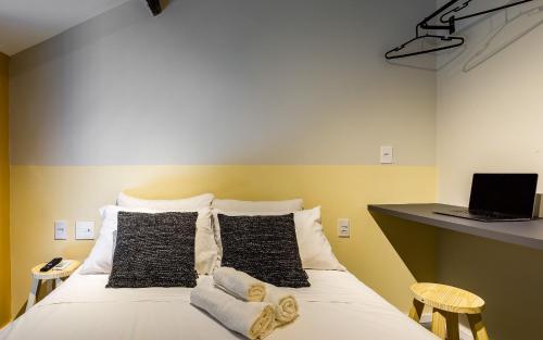 a bedroom with a bed with black and white pillows at ZEST Pedroso in Sao Paulo