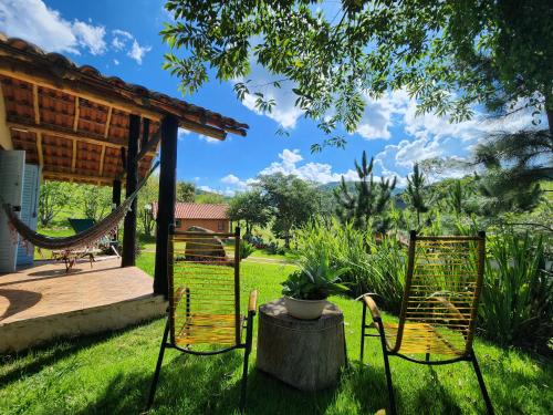 un patio con 2 sillas y una hamaca en Pousada Vale Monte Azul, en Santo Antônio do Pinhal
