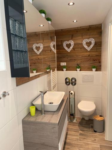 een badkamer met een wastafel en een toilet met harten aan de muur bij Hotel Waldhorn in Stuttgart
