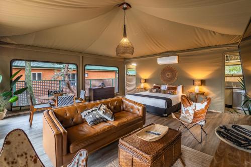 a living room with a bed and a couch in a tent at NRMA Broulee Holiday park in Broulee