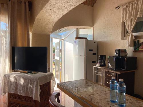 a kitchen with a counter with a television and a refrigerator at Casa de la Abuela in Ajijic
