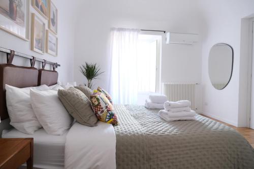- une chambre blanche avec un grand lit et des oreillers dans l'établissement Ventisei, à Catane