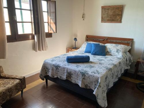 a bedroom with a bed with blue pillows on it at Las Margaritas in La Coronilla