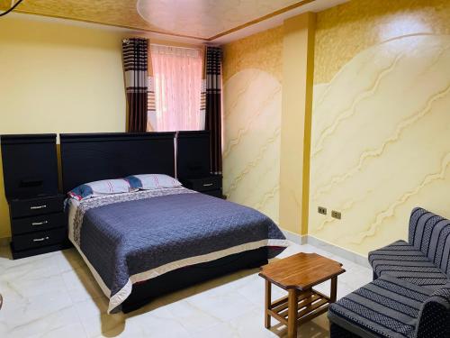 um quarto com uma cama, um sofá e uma cadeira em DIAMEZ HOTEL PLAZA em Sacaba