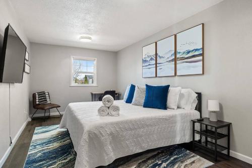 una camera da letto con un grande letto bianco con cuscini blu di Gazebo 4BR Ping Pong Arcade Room a Rapid City