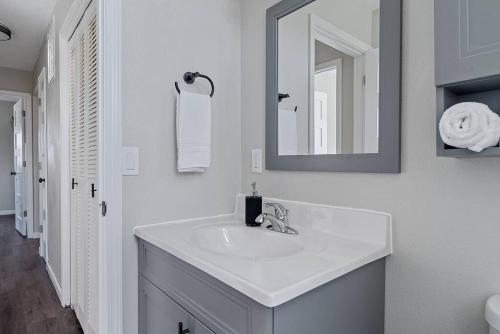 a white bathroom with a sink and a mirror at Gazebo 4BR Ping Pong Arcade Room in Rapid City