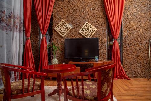 a living room with red curtains and a tv at Green Villa Apartments in Kampala