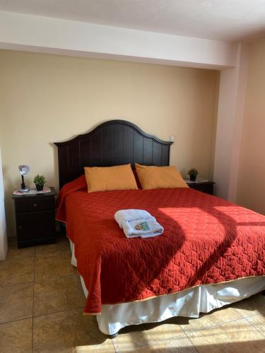 1 dormitorio con cama roja y manta roja en Apartamento #3 Portal de Occidente, en Quetzaltenango