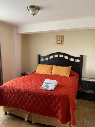 um quarto com uma cama vermelha e um cobertor vermelho em Apartamento #6 Portal de Occidente em Quetzaltenango