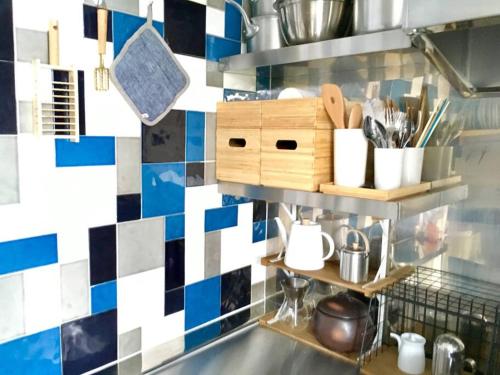 cocina con azulejos azules y blancos en la pared en Izu Cliff House. Open Ocean Views. National Park., en Ihama