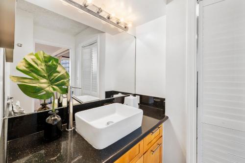a bathroom with a sink and a mirror at Aloha Getaway, Ocean View Condo Near Waikiki Beach with Free Parking in Honolulu