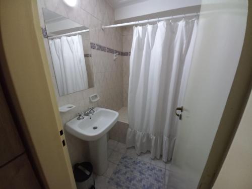 a white bathroom with a sink and a shower at LA SAN JUAN en Zona Norte in San Miguel de Tucumán
