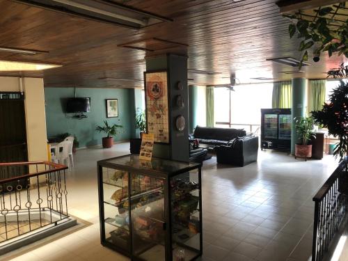 um átrio com uma sala de estar com uma mesa em Hotel la colina em Cartago