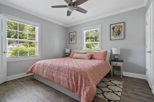 - une chambre avec un lit avec une couette rose et 2 fenêtres dans l'établissement Cheerful 3 bedroom-long term close to uptown, à Charlotte