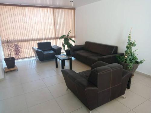 uma sala de estar com um sofá e duas cadeiras em Casa Ejecutiva en Gran Jardin em León