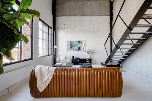 a living room with a couch and a staircase at New York Converted Warehouse Apartment in Richmond in Melbourne