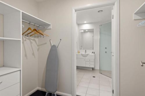 a white bathroom with a sink and a mirror at Pacific Blue 520 private pool air conditioning and Wi Fi in Salamander Bay