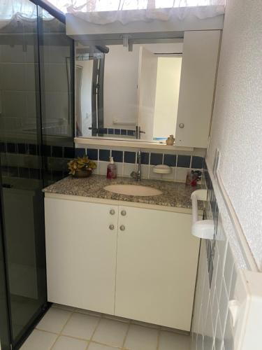 a bathroom with a sink and a mirror at condomínio Porto di Mare Casa 22 ALAGOAS in Paripueira