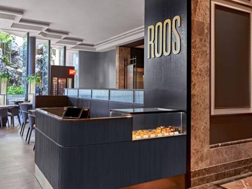 a restaurant with a counter with food on it at Vibe Hotel Singapore Orchard in Singapore