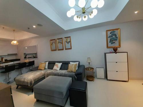 a bedroom with a bed and a couch and a table at The Mansion Kemayoran, lovely 3 bed apartment. in Jakarta