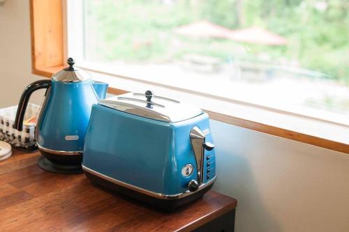 einem blauen Toaster auf einer Theke neben einem Fenster in der Unterkunft Bandi House in Seogwipo