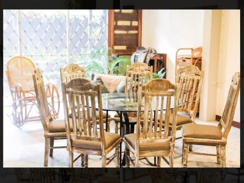 a glass table with chairs and a tableasteryasteryasteryasteryasteryasteryasteryastery at Balay 8 Suites in Silay