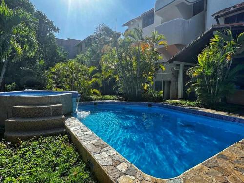 a large blue swimming pool in front of a house at Un rinconcito en Pampatar in Pampatar