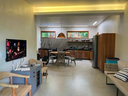 a living room with a kitchen and a dining room at Cumuru pé na areia in Cumuruxatiba