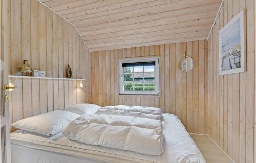 a bedroom with a bed with white sheets and a window at Gorgeous Home In Hemmet With Sauna in Hemmet