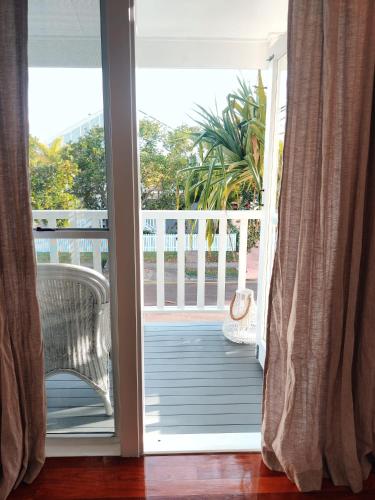 an open door to a balcony with a chair at Eugarie Seaside Guesthouse in Marcoola