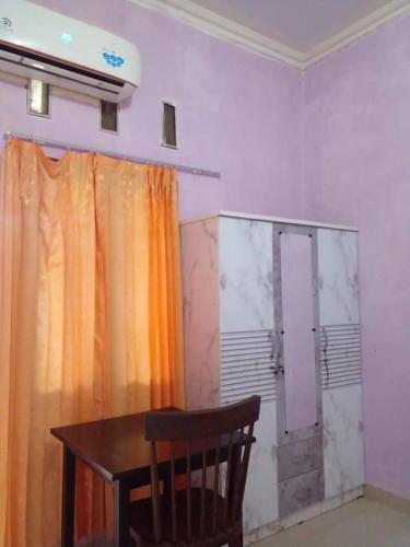 um quarto com uma mesa e uma cortina e uma porta em BRAVILIA GUEST HOUSE em Sorong