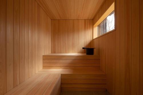 a sauna with a window and a wooden wall at Tatehata House. Private Sauna. Outdoor Bath. in Kita-karuizawa