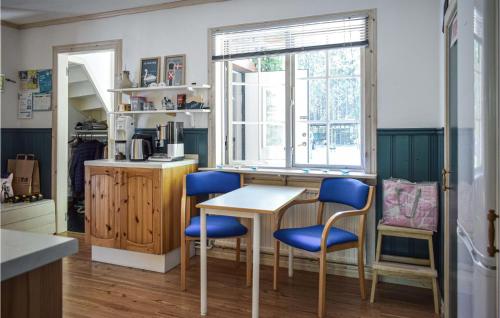 Ryd的住宿－4 Bedroom Gorgeous Home In Ryd，厨房配有桌子和蓝色的椅子