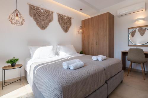 a bedroom with a bed with towels on it at OSSIANO POOL VILLAS, Heating Pool, 2 min drive to Haraki Beach & 10 to Lindos in Haraki