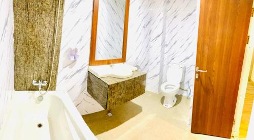 La salle de bains est pourvue d'un lavabo, d'un miroir et d'une baignoire. dans l'établissement The Bonte Hotel, à Puunggolaka