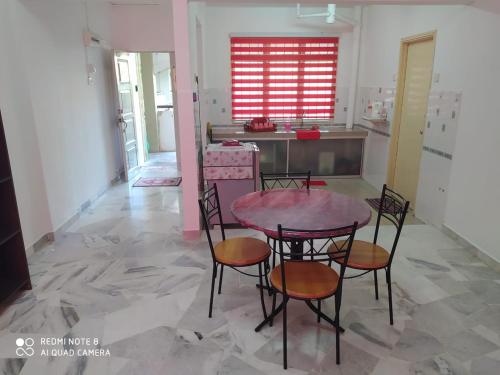 a room with a table and chairs and a kitchen at PD Laguna Homestay Red in Port Dickson