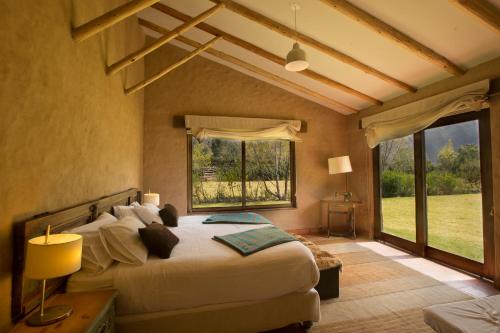 a bedroom with a large bed and a large window at Luxury House at Sacred Valley Urubamba Cusco The Mountain Star in Urubamba