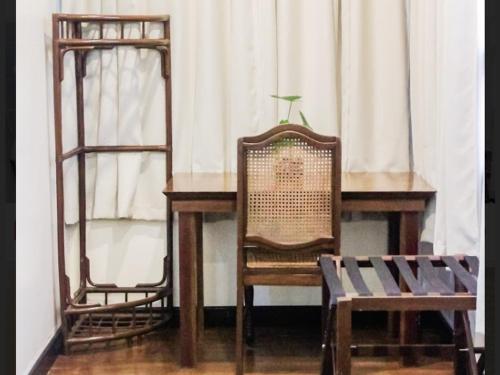 a wooden table with a chair and a desk with a chair at Balay 8 Suites in Silay