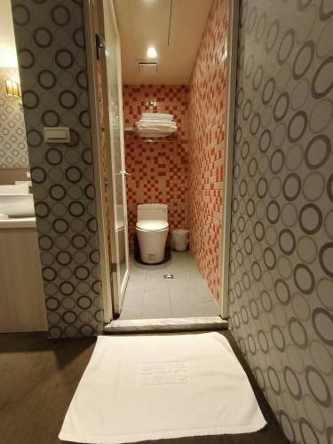 a bathroom with a toilet and a white rug at Taiwan Seven Days Boutique Hotel in Taipei