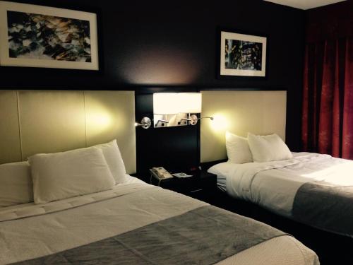a hotel room with two beds and a lamp at Cherokee Grand Hotel in Cherokee
