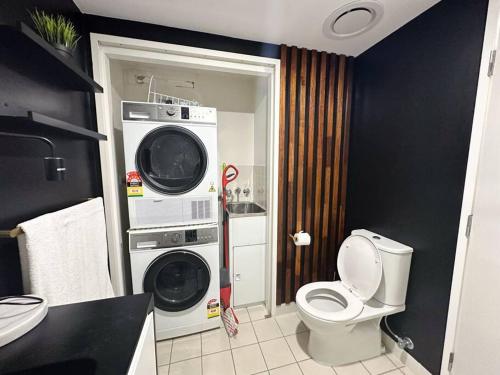 een badkamer met een toilet, een wasmachine en een droger bij S&P - Festival in Brisbane